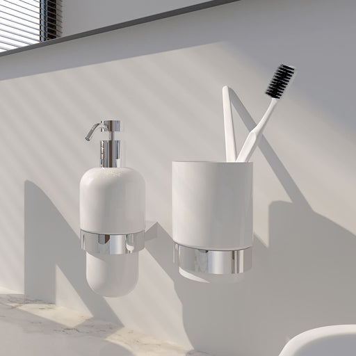 Architecto Seifenspender und Becherhalter aus Keramik von ALISEO. An einer weißen Wand in einem hellen, weißen Badezimmer montiert.