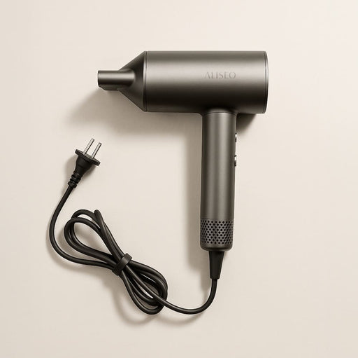 Der moderne und minimalistische Haartrockner VENTO von ALISEO in der Farbe Dunkelgrau-metallic liegt auf einem hellen Hintergrund.