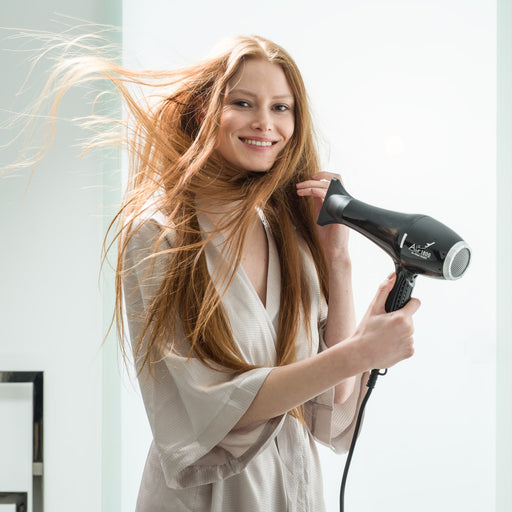 Frau mit langen Haaren verwendet schwarzen Air 1800 Haartrockner. Weiche Linien, glatte Texturen, sanfte Farben.
